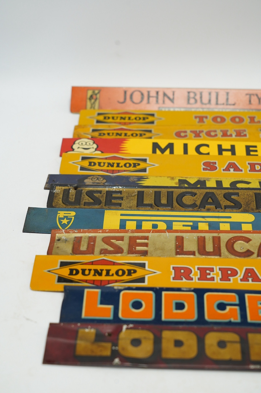 Motoring interest: twelve mid century tinplate advertising shelf strips, largest 48cm, together with a Michelin printed card advertising sign. Condition - poor, fair and good